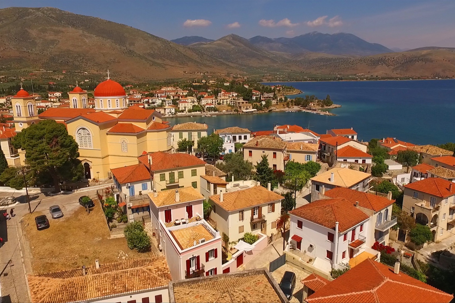aerial drone photo of galaxidi port with red roofs and blue sea