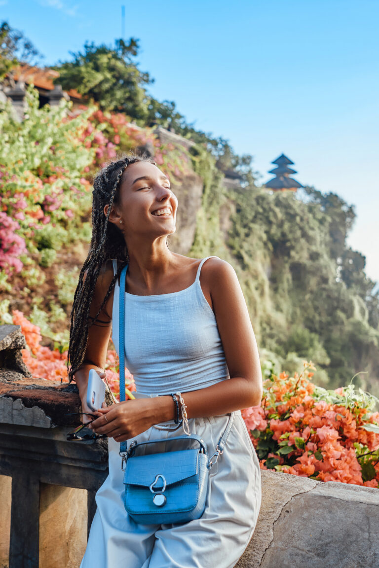 Shot of pretty woman wearing white casual clothing against mountain landscape.
