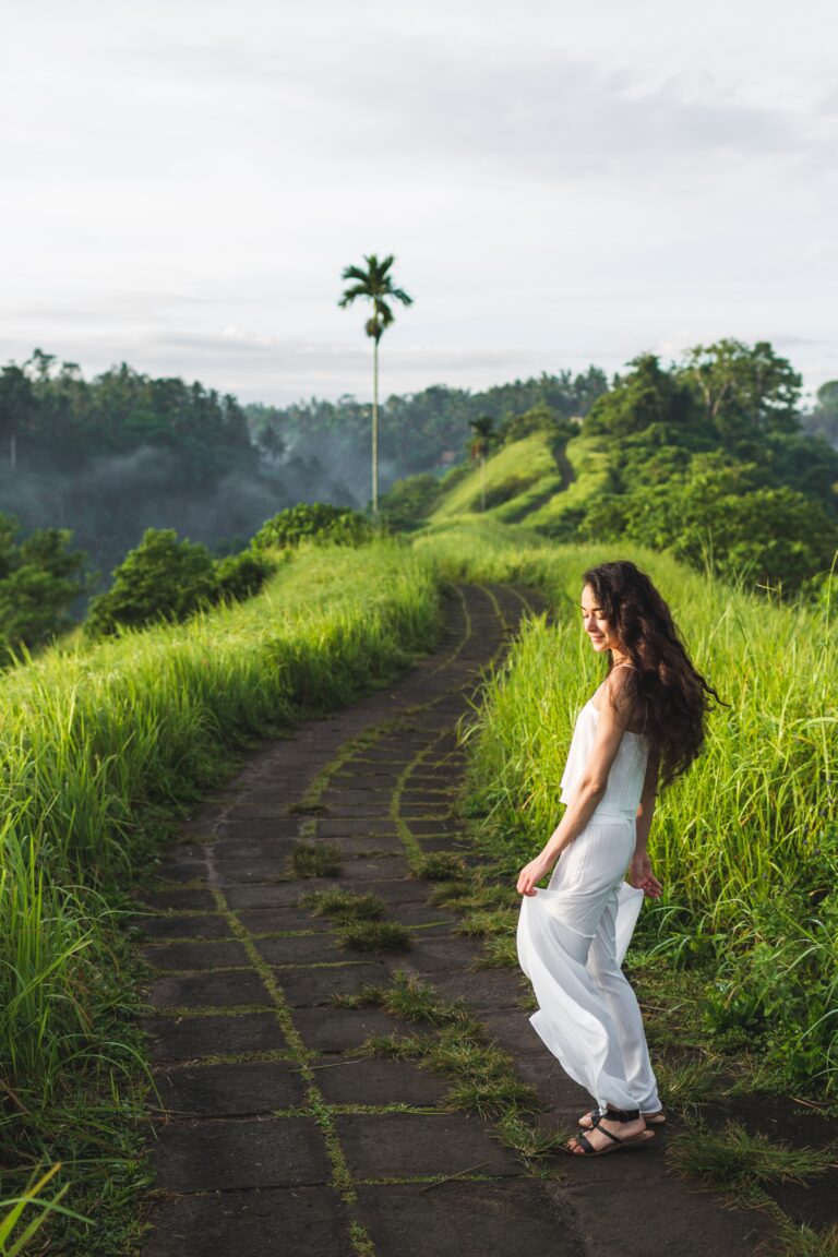 Young beautiful woman walking on Campuhan Ridge way of artists, in Bali, Ubud. Beautiful calm sunny morning